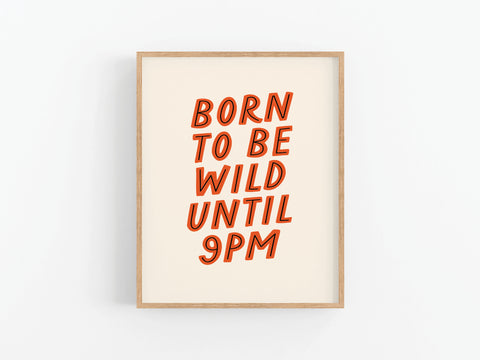 The Onderkast Studio Born To Be Wild Art Print features bold red and orange text reading “BORN TO BE WILD UNTIL 9PM” on a white background, with vibrant colors and high-quality production in a stylish frame.