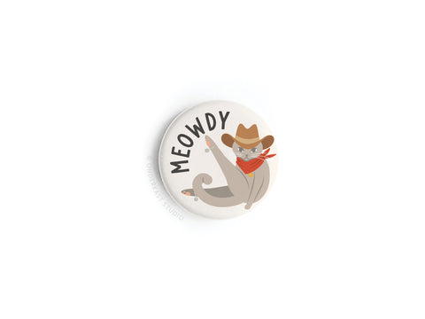 The Meowdy Button Magnet by Onderkast Studio showcases a cartoon cowboy cat with a hat, red bandana, and raised paw on a white background. MEOWDY appears above, making it perfect for cat lovers.