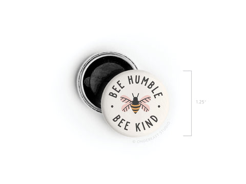 The Bee Humble Bee Kind Button Magnet by Onderkast Studio features a whimsical bee at the center, encircled by “BEE HUMBLE BEE KIND” on a 1.25-inch round pinback with a black back—ideal as a magnet or fun accessory!.