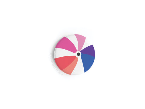 The Onderkast Studio Beachball Button Magnet features a vibrant beach ball design in pink, blue, purple, red, and white segments, displayed on a plain white background for an eye-catching look.