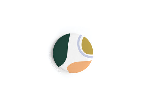 The Abstract No. 1 Button Magnet by Onderkast Studio features a modern, minimalist design with green, mustard yellow, orange, white, and light blue curved shapes on a white background. This product is discontinued.