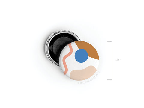 The Onderkast Studio Abstract No. 2 Button Magnet – DISCONTINUED features a 1.25-inch round design with beige, brown, pink, and blue on white. It displays vibrant, high-quality colors and includes an open black backing.