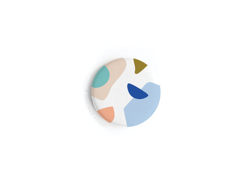 The Onderkast Studio Abstract No. 4 Button Magnet features abstract shapes in pastel hues, vibrantly printed on a white background and displayed on a plain surface. This product is discontinued.