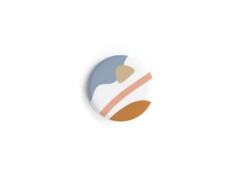 The Abstract No. 6 Button Magnet by Onderkast Studio features a minimalist, modern design with curved shapes in blue, beige, peach, and brown on white. This high-quality magnet is vibrantly printed but now discontinued.
