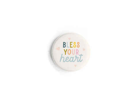 The Bless Your Heart Button Magnet by Onderkast Studio features pastel lettering and pink hearts on white—an ideal way to add Southern sass to your space.