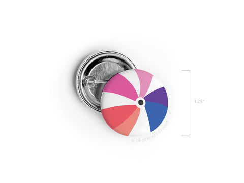 The Onderkast Studio Beachball Pinback Button is a 1.25-inch accessory with a vibrant design of pink, white, blue, red, and purple segments. Both front and back are shown on a white background.