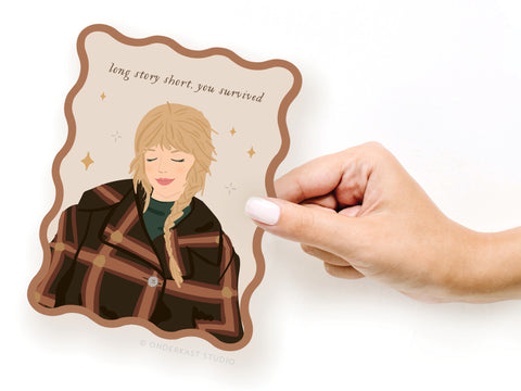 A hand holds the TS Evermore Wavy Die Cut Notecard by Onderkast Studio, featuring an illustrated person in a brown coat and sparkles, with the text long story short, you survived above.