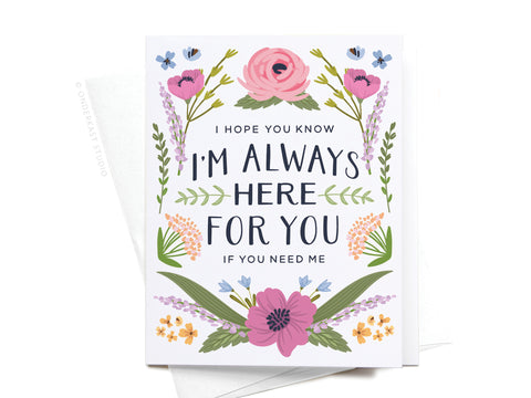 The “I’m Always Here For You Greeting Card” by Onderkast Studio features colorful flowers and leaves. Printed in the USA, this card includes two white envelopes, partially visible underneath.