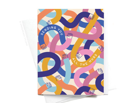 The Sending You All the Hugs Greeting Card by Onderkast Studio features cartoon arms in pastel colors with Sending You All the Hugs across them, plus an envelope peeking out from behind.