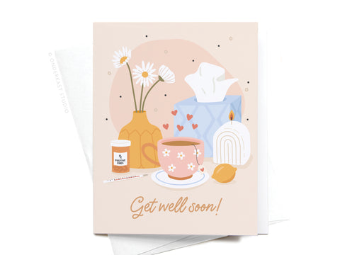 Onderkast Studio’s Get Well Soon Greeting Card features a mug, tissue box, and candle on a soft pastel background with “Get well soon!”—a premium way to send heartfelt wishes.
