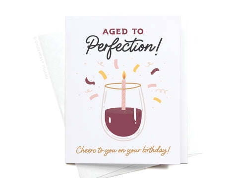 The Aged to Perfection Wine Greeting Card by Onderkast Studio features a wine glass with a lit candle, confetti accents, and the message: Aged to Perfection! Cheers to you on your birthday!.