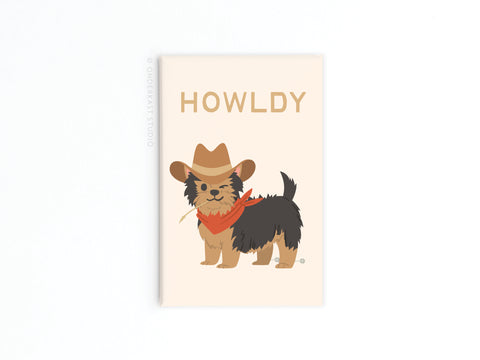 The Onderkast Studio Howldy Dog Refrigerator Magnet features a small dog in a cowboy hat and red bandana with HOWLDY above, adding playful charm to any fridge.