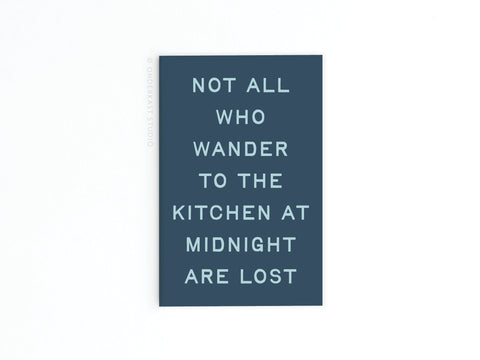 The Not All Who Wander to the Kitchen Refrigerator Magnet by Onderkast Studio features dark blue with white text: NOT ALL WHO WANDER TO THE KITCHEN AT MIDNIGHT ARE LOST. A fun, inspiring accent for your fridge or kitchen space.