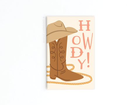 The Howdy Boot Refrigerator Magnet by Onderkast Studio features a playful HOWDY! above cowboy boots, a hat, and rope—add this fun Western flair to your fridge for charming Old West decor.