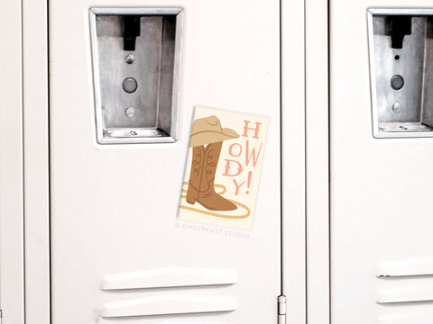 The Howdy Boot Refrigerator Magnet by Onderkast Studio features a cowboy boot, hat, rope, and bold “HOWDY!”—adding Old West charm and Western flair to any space.