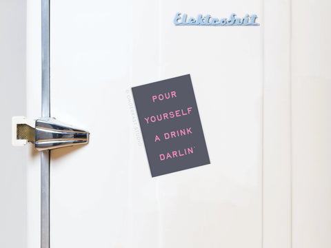 Add playful charm to your kitchen with the Pour Yourself a Drink Darlin’ refrigerator magnet by Onderkast Studio—a pink-lettered sign on a dark background, designed to stand out on any fridge.