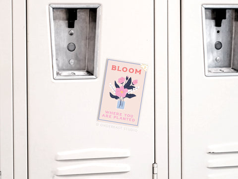 The Onderkast Studio Bloom Where You Are Planted Refrigerator Magnet, featuring a floral vase illustration and motivational message, adds an inspiring touch to your decor when placed on any locker or fridge.