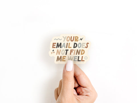 A hand with white-painted nails holds the Onderkast Studio Your Email Does Not Find Me Well Sticker, a witty burnout badge, against a plain white background. Printed in the USA.