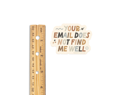 A wooden ruler lies beside the Onderkast Studio Your Email Does Not Find Me Well sticker, featuring playful fonts on a white background. About two inches tall, its the perfect burnout badge for your workspace.