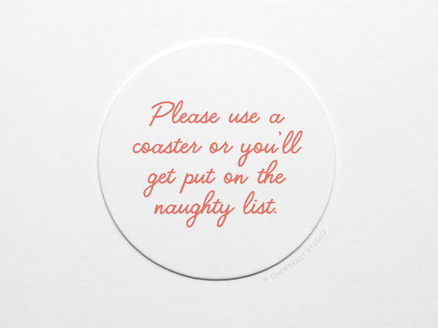 The Naughty List Coaster Set by Onderkast Studio features round white letterpress coasters with red cursive text: Please use a coaster or you’ll get put on the naughty list. Handmade on durable pulp board.