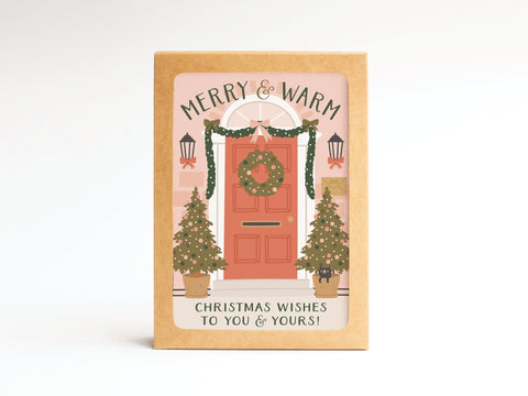 The Merry & Warm Christmas Wishes Folded Greeting Note Set of 10 by Onderkast Studio features a festive red door scene and garlands, reads Merry & Warm and Christmas Wishes to You & Yours!, and is proudly printed in the USA.