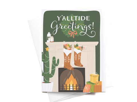 Send festive cheer with the Onderkast Studio Yalltide Greetings! Folded Greeting Note Set of 10—premium cards printed in the USA, featuring cowboy boots as stockings, gifts, a cactus with lights, and a cozy mantel scene.