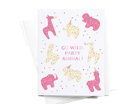 Onderkast Studio’s Go Wild Party Animal Frosted Cookies Greeting Card features playful giraffes, elephants, and hippos with polka dots and party hats. Perfect for birthdays, it reads: Go wild, party animal!.