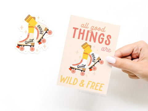 A hand holds the Onderkast Studio All Good Things Are Wild & Free Rollerskates greeting card, printed on white card stock with a retro skate design. A matching vinyl sticker is placed next to the card.