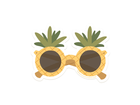 Onderkast Studio’s Pineapple Sunglasses Sticker features yellow, crisscrossed, pineapple-shaped frames with green leaves and dark-tinted round lenses—a fun, durable vinyl accessory for your tropical style.