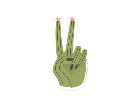 The Onderkast Studio Cactus Peace Sign Sticker features a green hand-shaped cactus with pink flowers on the raised fingers and black thorns as nails, printed on durable vinyl.