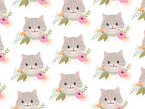 The Tabby Cat Floral Sticker by Onderkast Studio features seamless gray tabby cat faces with pink cheeks, pastel flowers, and green leaves on white vinyl. Water resistant and durable—perfect for adding cute charm anywhere!.