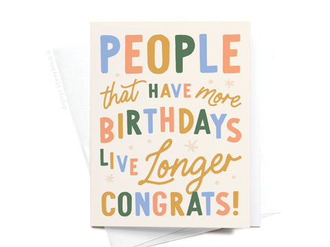 The “People That Have More Birthdays Live Longer” Greeting Card by Onderkast Studio features colorful text, star accents on a white background, and comes with an envelope. Printed in the USA.