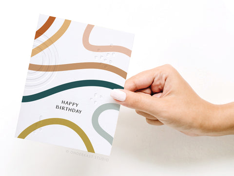 a hand holding a card with a happy birthday message
