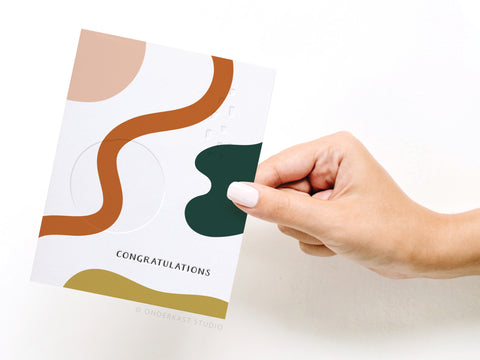a hand holding a card with a design on it