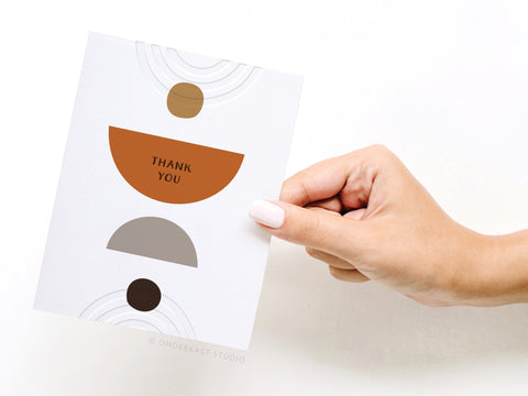 a hand holding a card with a design on it